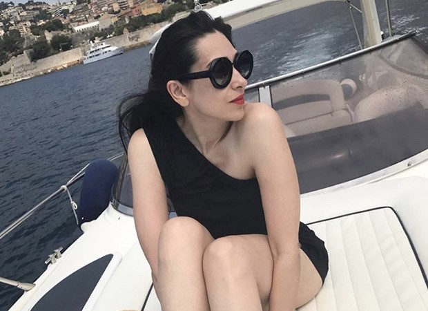 Karisma Kapoor is hotness overloaded in a sultry black off-shoulder monokini while soaking up the sun on a boat