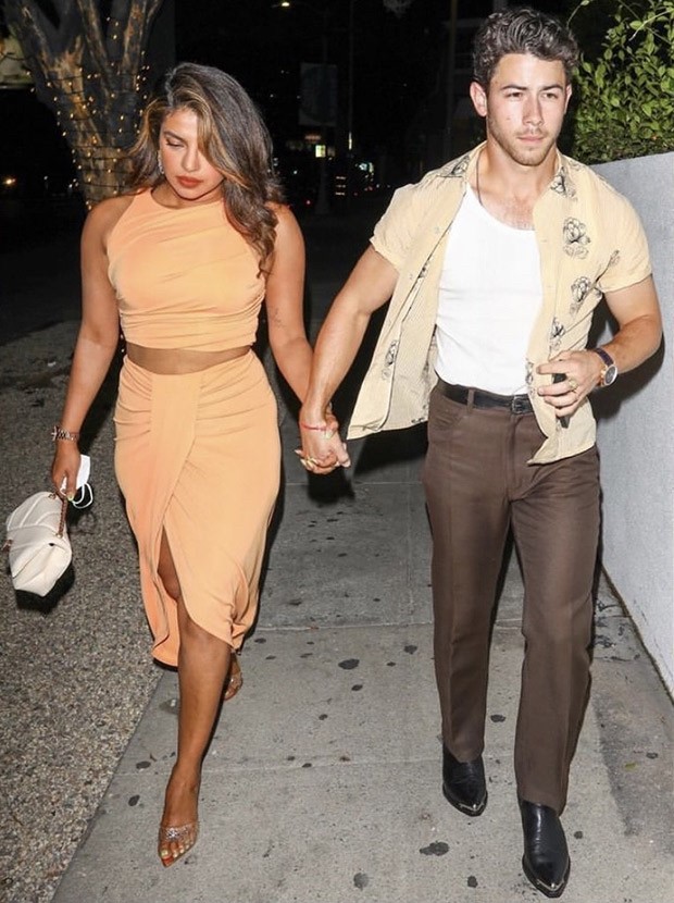 Priyanka Chopra in a salmon crop top and skirt and Nick Jonas in a tank top and an unbuttoned shirt spotted holding hands post dinner date