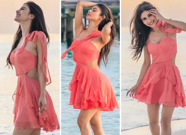 Mouni Roy lounges on the sea rocks in baby pink bralette top