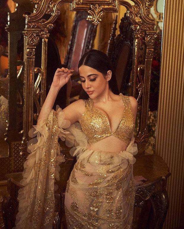 Uorfi Javed is coated in gold as she drapes an extravagant gleaming saree created by the designer duo Abu Jani and Sandeep Khosla 