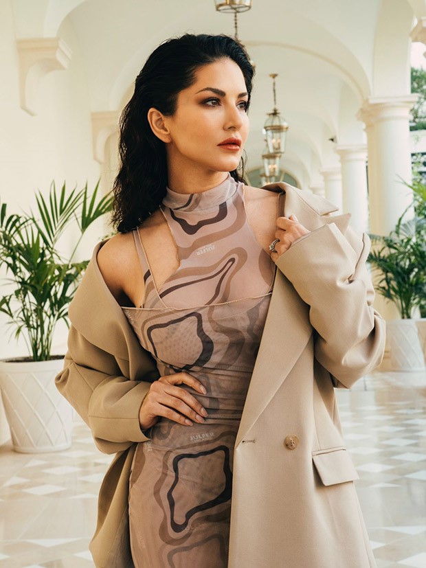 Cannes 2023: Sunny Leone mesmerizes in a sheer brown cut-out midi dress, accompanied by a chic beige overcoat