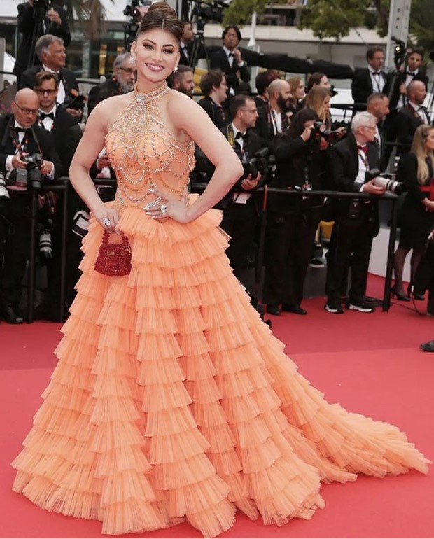 Urvashi Rautela steals the spotlight at Cannes 2023, adorned in an orange frill gown that exudes ethereal beauty and unmatched glamour