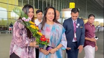 Fan gifts a bouquet of flowers to Hema Malini at the airport