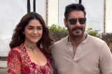 Mrunal Thakur with a glamour red fit pose with co star Ajay Devgn