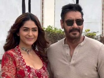 Mrunal Thakur with a glamour red fit pose with co star Ajay Devgn