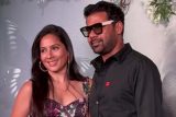 Shabir Ahluwalia in an all black outfit pose with his wife